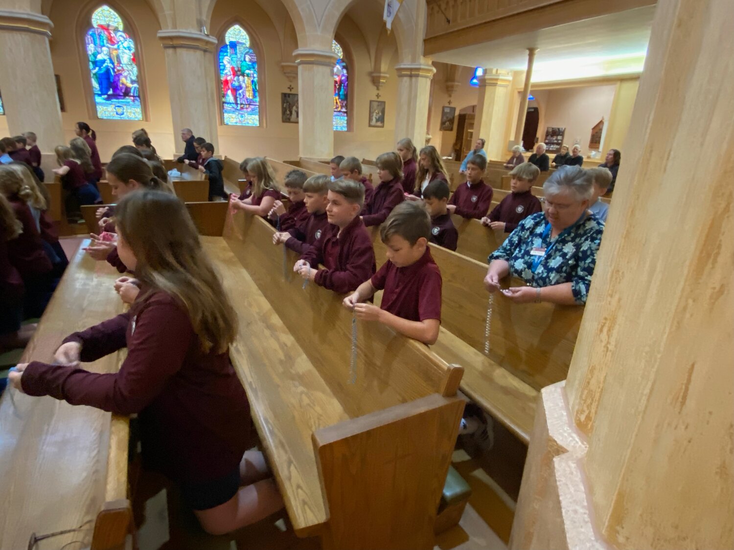Students of St. George School in Hermann gather in church to pray the Rosary together.